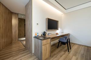 杭州杭州下沙亚朵酒店的配有书桌和电视的酒店房间