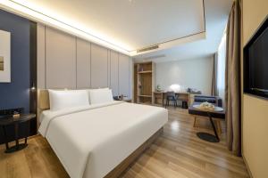杭州杭州下沙亚朵酒店的一间带一张白色大床的卧室和一间客厅