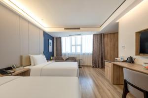 杭州杭州下沙亚朵酒店的有两张床和一台电视的酒店房间