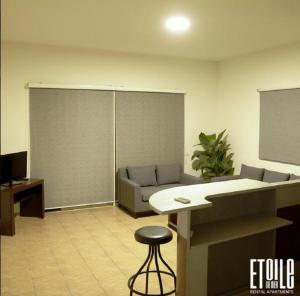 a living room with a couch and a stool at Etoile DE Mer in Al ‘Ayn