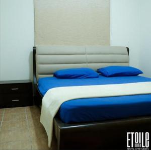 a bedroom with a bed with blue pillows on it at Etoile DE Mer in Al ‘Ayn