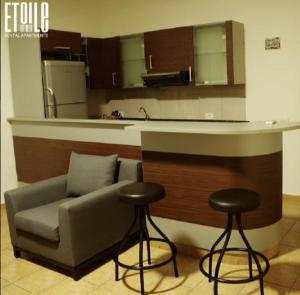 a living room with a couch and two bar stools at Etoile DE Mer in Al ‘Ayn