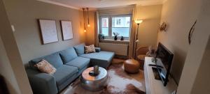 a living room with a blue couch and a window at Büsumhaus Birgit in Büsum