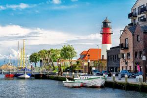 a red and white lighthouse and boats in the water at Büsumhaus Birgit in Büsum