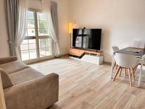 a living room with a couch and a flat screen tv at Guest House - La bella vita in Orosei