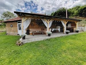 a pavilion with a table and chairs in a yard at Apartmani Ruj in Soko Banja