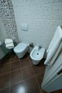 a white bathroom with a toilet and a sink at Apartament Vila 12 in Durrës +17 photos
