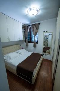 a bedroom with a large bed and a mirror at Apartament Vila 12 in Durrës