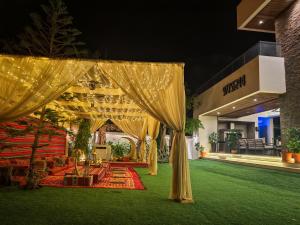 a tent in the middle of a lawn with lights at G R A N D C H A L E T in Salalah