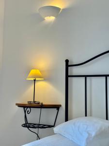a lamp on a table next to a bed at Grupo Morgado - Quinta do Morgado - Morgado Pool View in Tavira