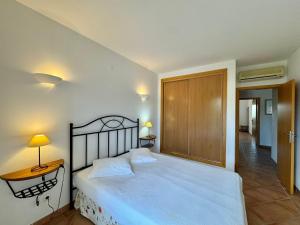 a bedroom with a bed and a table and lamp at Grupo Morgado - Quinta do Morgado - Morgado Pool View in Tavira