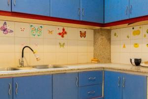 a kitchen with blue cabinets and a sink at Behomy Metropolim in Jakarta