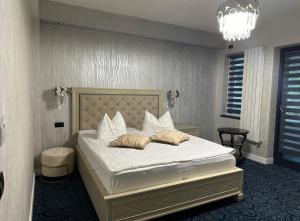 百乐·奥拉内斯蒂Pensiunea Izvoare Olanesti 3***的卧室里有一张床，床单和枕头都是白色的 更多45张照片