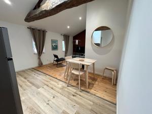 a dining room with a table and a mirror at Le Terre & Mer - Proche Saint Emilion in Saint-Médard-de-Guizières