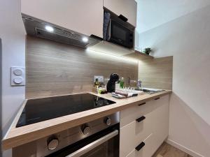 a kitchen with a sink and a microwave at Le Terre & Mer - Proche Saint Emilion in Saint-Médard-de-Guizières +8 photos