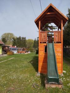 a play structure with a slide in the grass at Apartmán Greenhouse in Budikovany