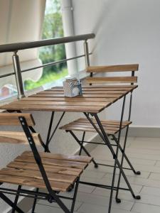 a wooden table with two chairs and a cup on it at Maison de jolie in Golem +3 photos