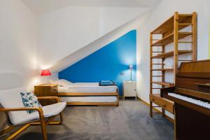 a bedroom with a blue wall and a bed and a piano at finaly peace in Geneva
