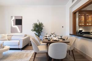 a living room with a table and chairs and a couch at Luxury 2BR Apartment in Downtown Dubai Burj Khalifa View Walk to Dubai Mall By ĀYA Boutique in Dubai