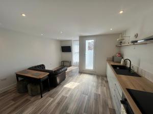 eine Küche und ein Wohnzimmer mit einer Couch und einem Tisch in der Unterkunft roof tops apartment in Ilfracombe + 4 Fotos