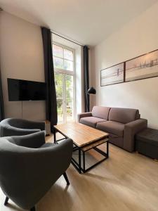a living room with a couch and a table and chairs at Le Clos - Centre ville - Jardin - Parking privé in Poitiers