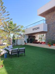 a building with two benches in a yard at G R A N D C H A L E T in Salalah