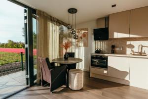 een keuken met een tafel en een keuken met rode tulpen bij Bos, duin en strand huisje in Noordwijk
