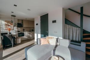 een woonkamer met een bank en een keuken bij Bos, duin en strand huisje in Noordwijk
