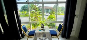 a table and chairs in front of a large window at Tiny Island Lake Lodge in Bangkok