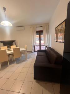 a living room with a black couch and a table at Il Cavalluccio Marino in Ladispoli