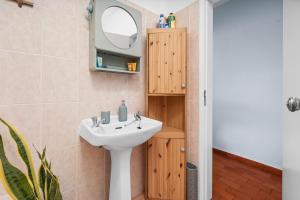 a bathroom with a sink and a tv on the wall at Casa Indie in Burgau +19 photos