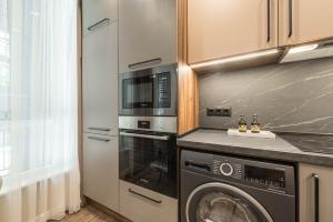 una cocina con lavadora y microondas en City Center Luxury Studio, en Varna