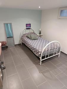 Bett in einem Zimmer mit Fliesenboden in der Unterkunft Vacances comme à la maison in Arnouville-lès-Gonesse