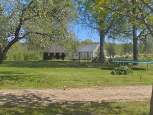 a park with a house and a trampoline in the grass at Melleņu ligzda in Puršēni