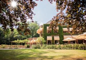 Un gran edificio con hiedra en el costado. en Landgoed Huize Bergen Den Bosch - Vught, en Den Bosch
