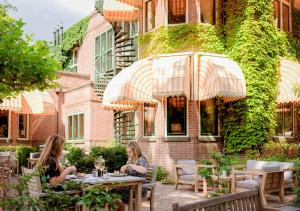 two women sitting at tables in front of a building at Landgoed Huize Bergen Den Bosch - Vught in Den Bosch