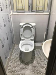 une petite salle de bain avec toilettes et lavabo dans l'établissement London Guest House, à Hong Kong