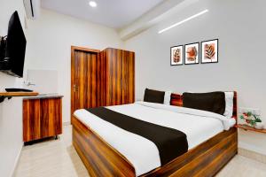 a bedroom with a large bed with a wooden headboard at Super Hotel O Sadar Bazar Gurgaon in Gurgaon