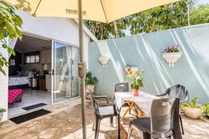 a patio with a table and chairs and an umbrella at Muthaiga Stays - Studio Venue in Durban