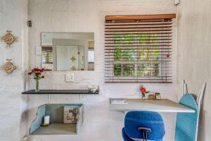 Muthaiga Stays - Studio Venue في ديربان: غرفة بها طاولة ومرآة وكرسي أزرق +36 صورة