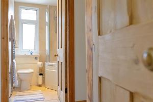a bathroom with a toilet and a sink and a window at Finest Retreats - Sea Bank in Colwyn Bay +23 photos