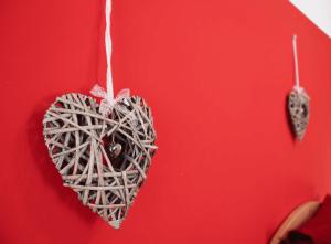 a heart ornament hanging on a red wall at Appartamenti al Parco in Molveno