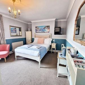 a bedroom with a bed and a table and a mirror at Bayliss Hall in Weymouth
