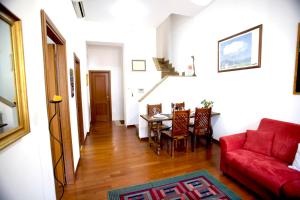 Una sala de estar con un sofá rojo y una mesa. en DomusVaticano, en Roma