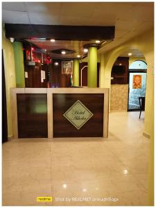 a lobby with a counter with a sign on it at HOTEL New Ashoka ! Near Maa Sidheshwari Kaali Badi - Prayagraj Rambag Railway Station in Prayagraj +18 photos