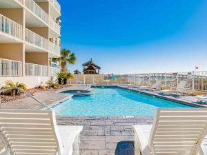 a swimming pool with chairs and a resort at Four Winds 301 in Orange Beach