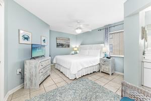 a bedroom with a white bed and a tv at Four Winds 301 in Orange Beach