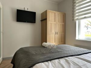 a bedroom with a bed and a flat screen tv at Jon`s Apartments in Pärnu