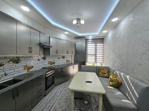 Una cocina con un sofá y una mesa en una habitación. en Апартаменты ЖК БАХМАЛ, en Samarkand
