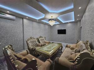 Habitación con sofás, mesa y TV. en Апартаменты ЖК БАХМАЛ, en Samarkand